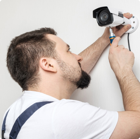CCTV installer fitting a security camera.